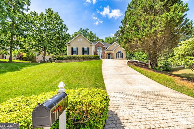 traditional-style house with driveway and a front yard