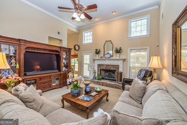 living area featuring carpet flooring, crown molding, ceiling fan, a towering ceiling, and a fireplace