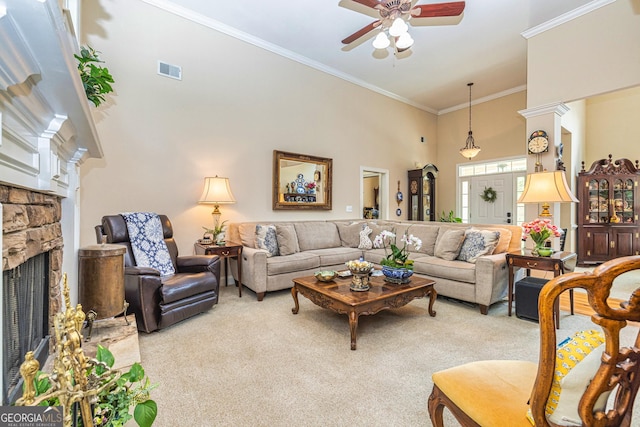 living room with light colored carpet, crown molding, a ceiling fan, a stone fireplace, and a high ceiling