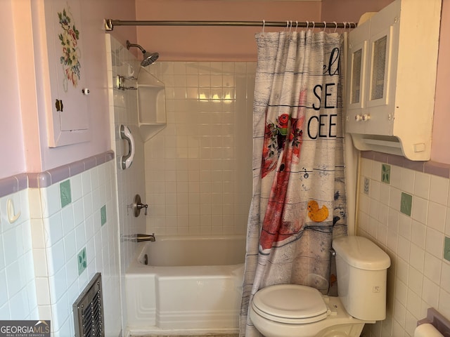 bathroom with tile walls, shower / bath combo with shower curtain, and toilet