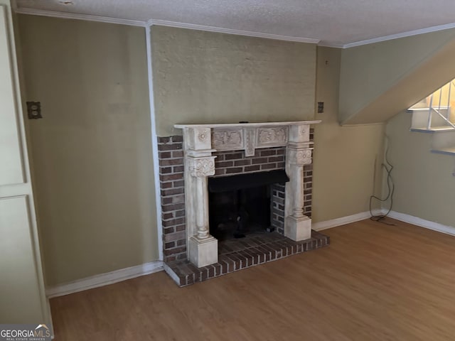 unfurnished living room with crown molding, baseboards, wood finished floors, and a fireplace