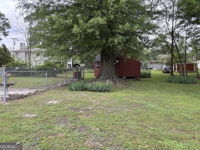 view of yard featuring an outdoor structure, fence, and a shed