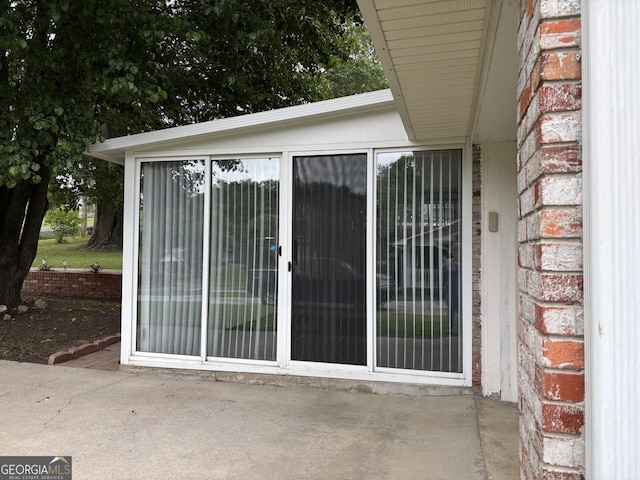 entrance to property featuring brick siding