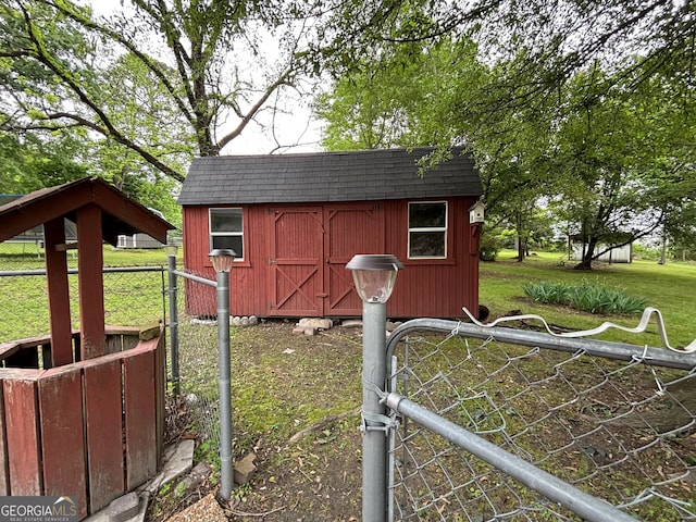 view of shed featuring fence and a gate