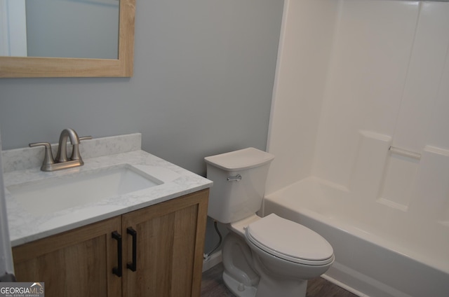 bathroom with shower / bathtub combination, toilet, wood finished floors, and vanity