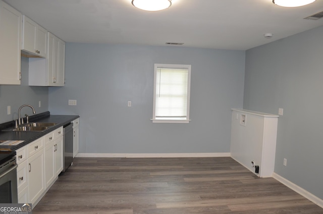 kitchen with appliances with stainless steel finishes, dark countertops, visible vents, and a sink