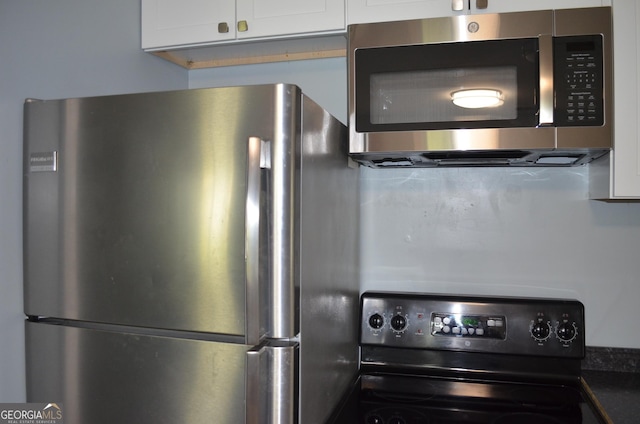 kitchen featuring white cabinets, dark countertops, and appliances with stainless steel finishes