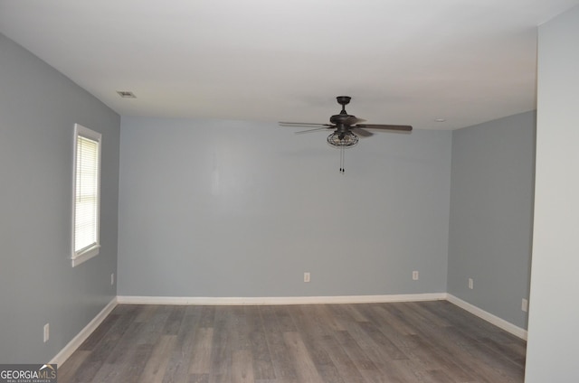unfurnished room with baseboards, ceiling fan, visible vents, and wood finished floors