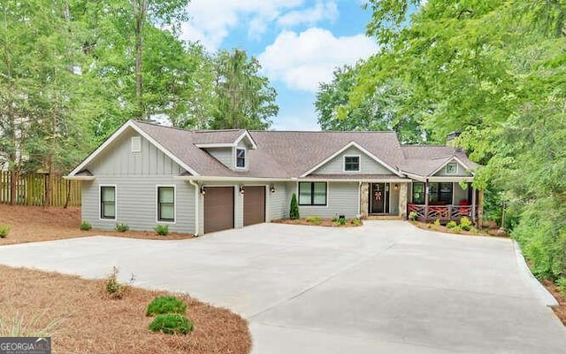 view of front of home featuring board and batten siding, driveway, covered porch, and a garage