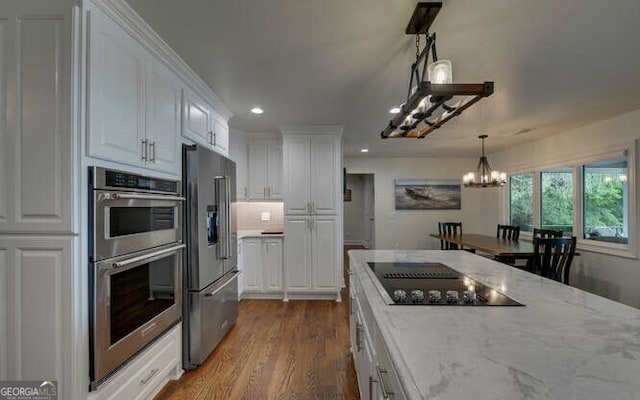kitchen with white cabinets, recessed lighting, a notable chandelier, and appliances with stainless steel finishes