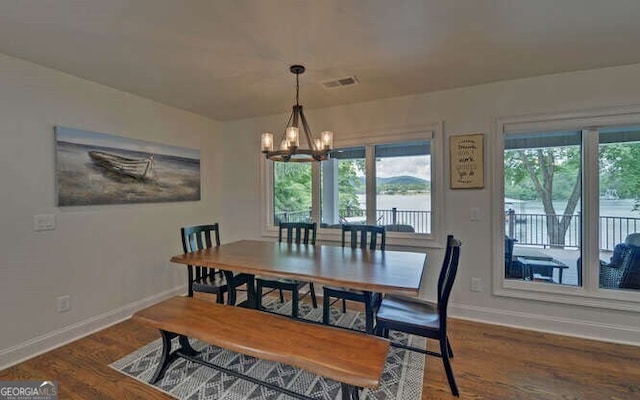 dining space with baseboards, wood finished floors, a notable chandelier, and visible vents