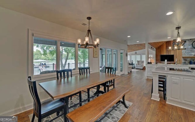dining area featuring a notable chandelier, recessed lighting, baseboards, wine cooler, and dark wood-style floors