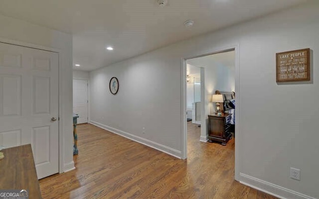 hallway with baseboards, recessed lighting, and wood finished floors