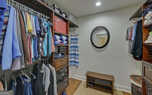 walk in closet with wood finished floors