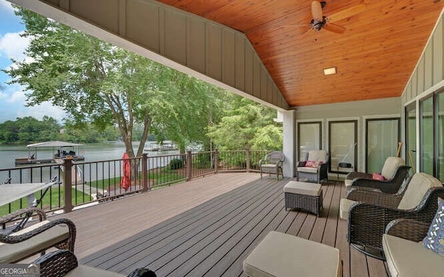 wooden deck with an outdoor hangout area, a ceiling fan, and a water view
