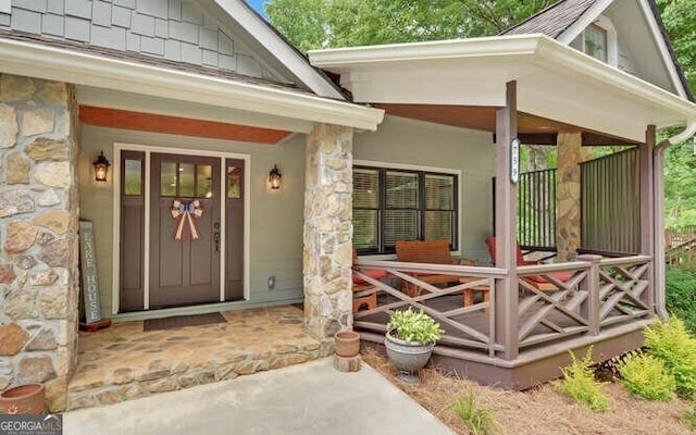 entrance to property featuring covered porch and stone siding
