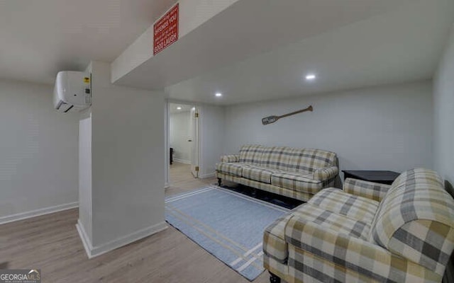 living area featuring recessed lighting, baseboards, a wall mounted AC, and wood finished floors