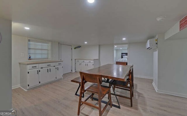 dining space with recessed lighting, baseboards, a wall unit AC, and light wood finished floors