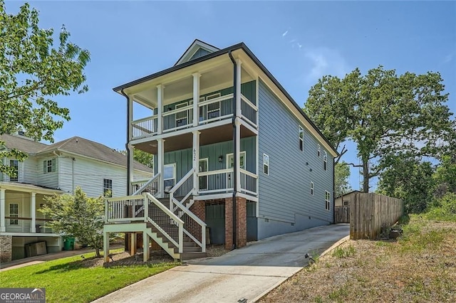 632 Warren Ave, Scottdale, GA 30079 - view of front of house featuring covered porch, fence, board and batten siding, a balcony, and stairs
