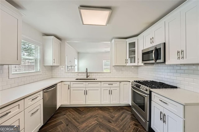 632 Warren Ave, Scottdale, GA 30079 - kitchen with white cabinetry, decorative backsplash, appliances with stainless steel finishes, and a sink