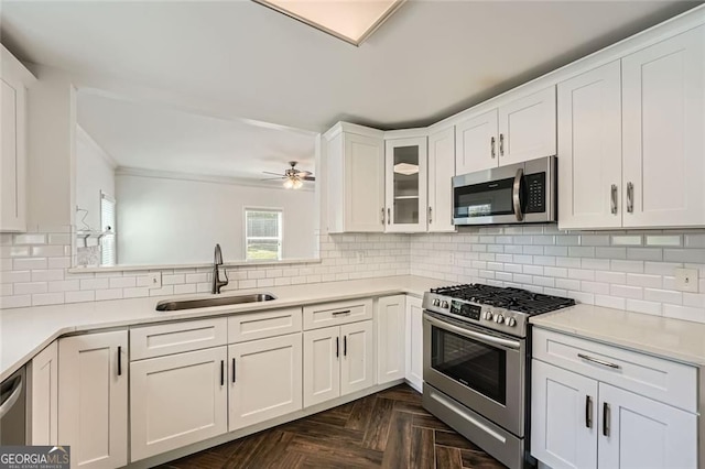 632 Warren Ave, Scottdale, GA 30079 - kitchen featuring glass insert cabinets, a sink, white cabinets, ceiling fan, and appliances with stainless steel finishes