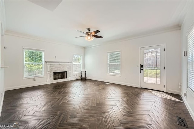 632 Warren Ave, Scottdale, GA 30079 - unfurnished living room with visible vents, crown molding, a ceiling fan, baseboards, and a stone fireplace