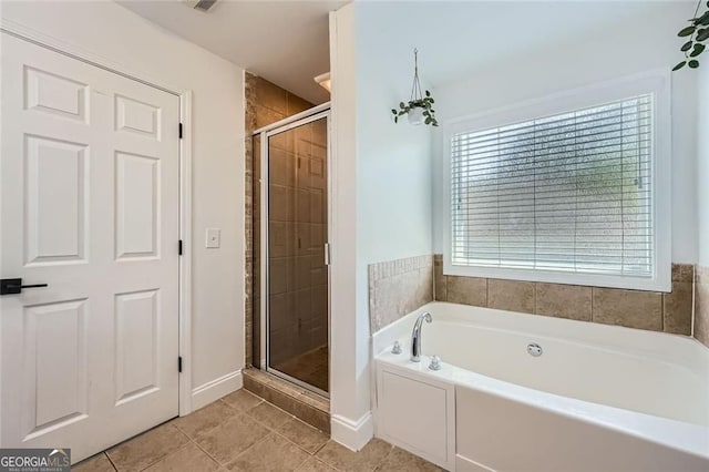 632 Warren Ave, Scottdale, GA 30079 - full bath featuring a shower stall, tile patterned flooring, a garden tub, and baseboards