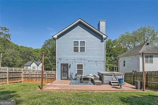 632 Warren Ave, Scottdale, GA 30079 - rear view of property featuring a chimney, a deck, a lawn, a hot tub, and a fenced backyard