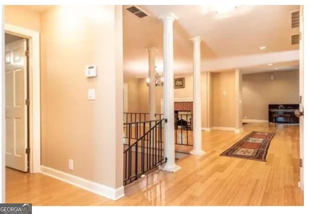 5325 Pheasant Run, Stone Mountain, GA 30087 - hall featuring visible vents, wood finished floors, baseboards, ornate columns, and an upstairs landing