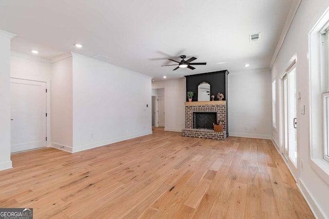 unfurnished living room featuring a wealth of natural light, ornamental molding, a ceiling fan, and visible vents