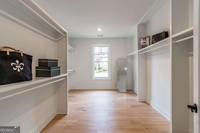 spacious closet featuring light wood-type flooring and visible vents