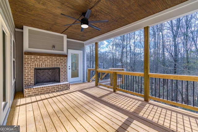 wooden deck with a ceiling fan and an outdoor brick fireplace