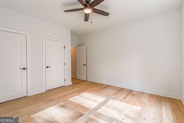 unfurnished bedroom with baseboards, a ceiling fan, and light wood-style flooring