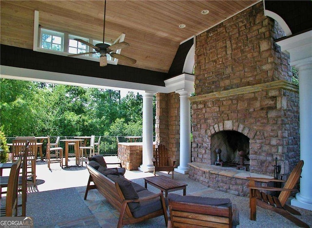 view of patio with a ceiling fan and an outdoor living space with a fireplace