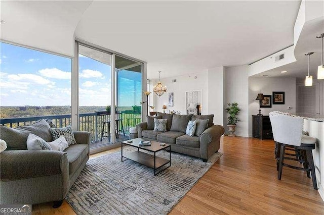 3300 Windy Ridge Parkway SE Unit 1401, Atlanta, GA 30339 - living area with a wall of windows, wood finished floors, visible vents, and an inviting chandelier