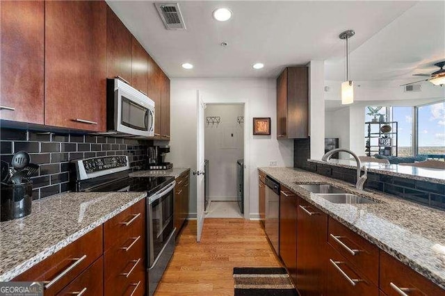 3300 Windy Ridge Parkway SE Unit 1401, Atlanta, GA 30339 - kitchen featuring visible vents, light wood-style floors, light stone counters, a sink, and appliances with stainless steel finishes