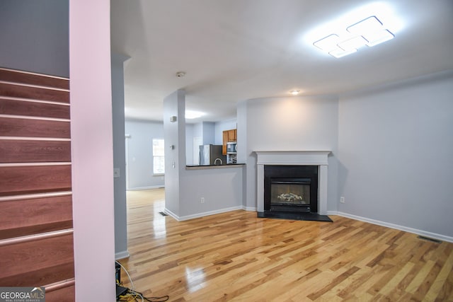 2201 Landing Walk Dr, Duluth, GA 30097 - unfurnished living room featuring baseboards, stairs, and wood finished floors