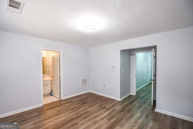 2201 Landing Walk Dr, Duluth, GA 30097 - unfurnished bedroom featuring connected bathroom, baseboards, visible vents, and wood finished floors