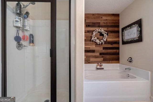 bathroom featuring wooden walls, a bath, and a stall shower