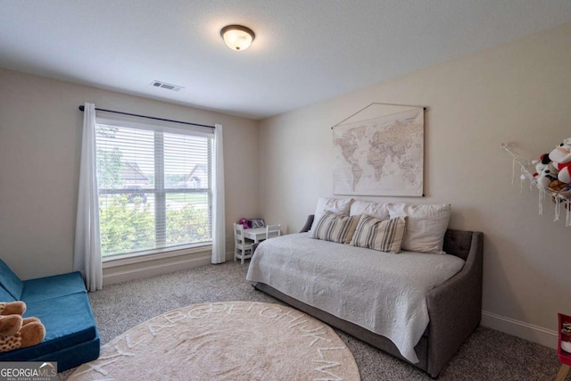 bedroom with baseboards, visible vents, and carpet