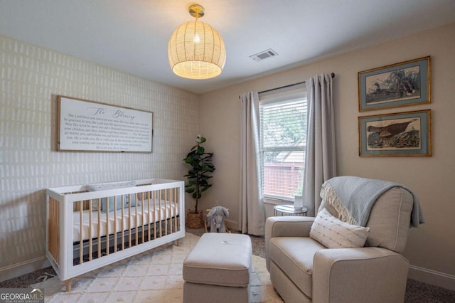 bedroom with baseboards, carpet, a nursery area, and visible vents