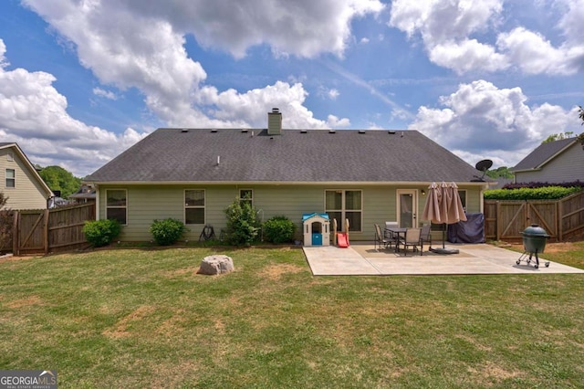 back of property featuring a patio, a fenced backyard, a lawn, and a chimney