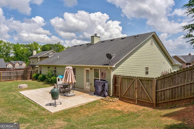 rear view of house featuring roof with shingles, a fenced backyard, a chimney, a patio area, and a yard