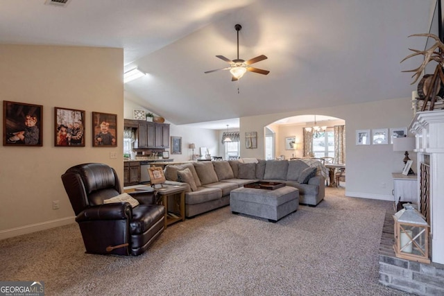 living room featuring arched walkways, vaulted ceiling, baseboards, carpet floors, and ceiling fan with notable chandelier