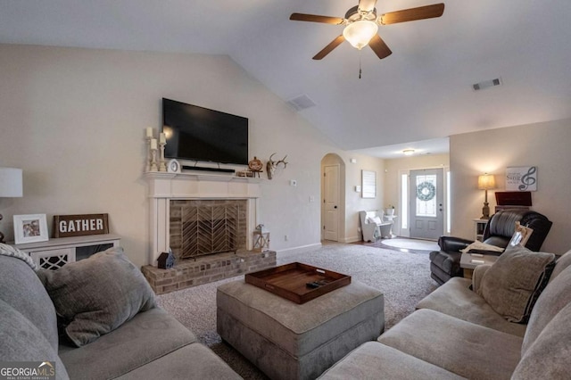 living room with ceiling fan, visible vents, arched walkways, a fireplace, and lofted ceiling