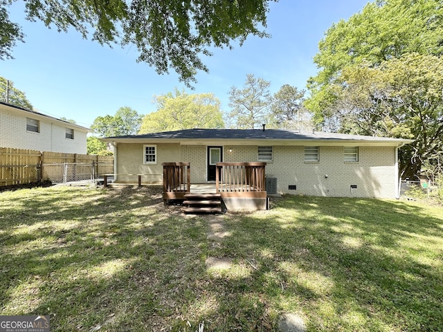 6507 Jackie Ln, Austell, GA 30106 - rear view of house featuring fence, a deck, brick siding, central AC unit, and a lawn
