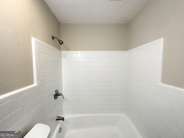 6507 Jackie Ln, Austell, GA 30106 - bathroom with a textured ceiling, shower / washtub combination, toilet, and tile walls