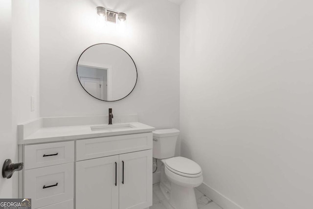 bathroom featuring toilet, baseboards, marble finish floor, and vanity