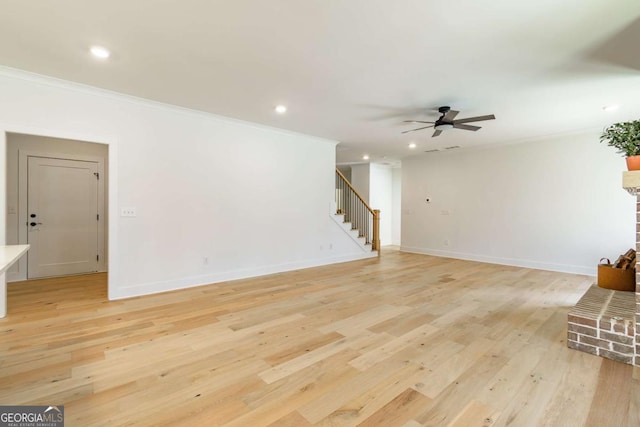 unfurnished living room with recessed lighting, ornamental molding, light wood finished floors, and stairs