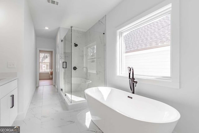 full bath with vanity, a marble finish shower, marble finish floor, a freestanding tub, and visible vents